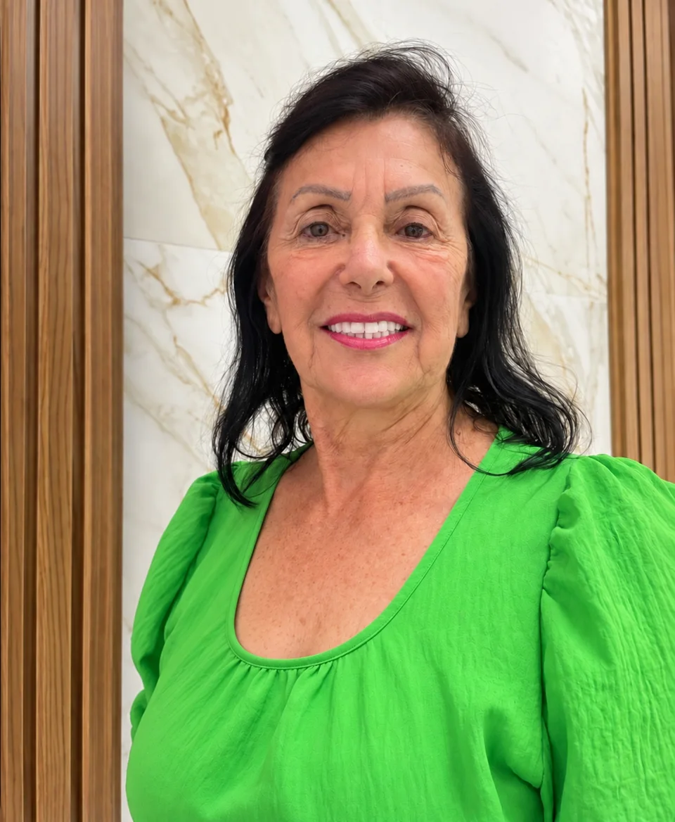 Cliente Odonto Guaratuba sorrindo, com blusa verde